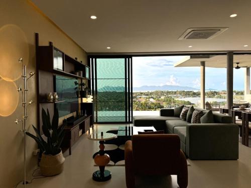 a living room with a couch and a large window at Villa La Lay By S&p Villa Management in Ban Tai