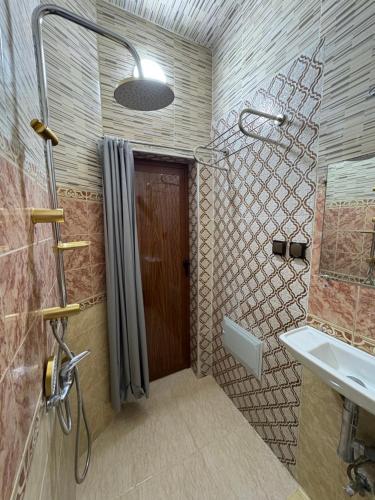 a bathroom with a shower and a brown door at Daryussef 114 in Marrakesh