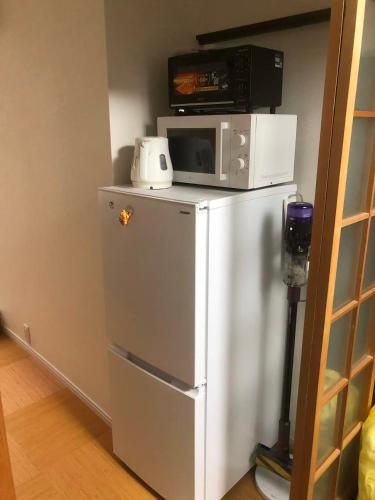 a microwave sitting on top of a refrigerator at TAKEITEI Japanese-style lodge in Kyoto
