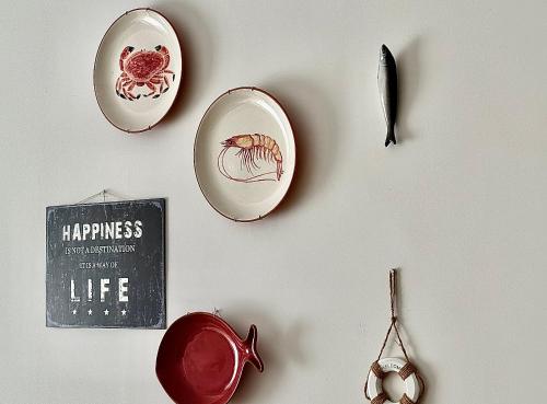 a wall with plates and utensils on a wall at Nazaré Beach Apartments in Nazaré