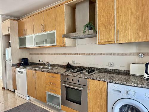 eine Küche mit Spüle und Geschirrspüler in der Unterkunft Nazaré Beach Apartments in Nazaré