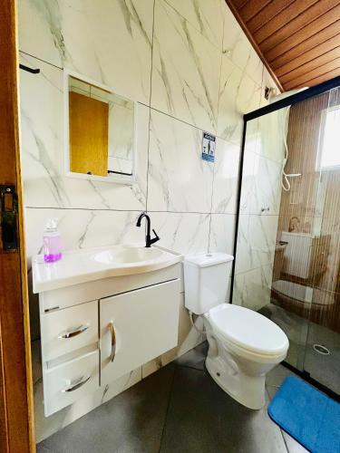 a white bathroom with a toilet and a sink at Estalagem Bernardinos in Camanducaia