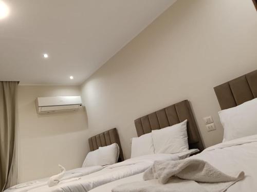 two beds in a room with white walls at Aurum Pyramids in Cairo