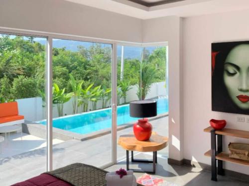 a living room with a view of a pool at Villa Natao by SP Villa Management in Mae Nam