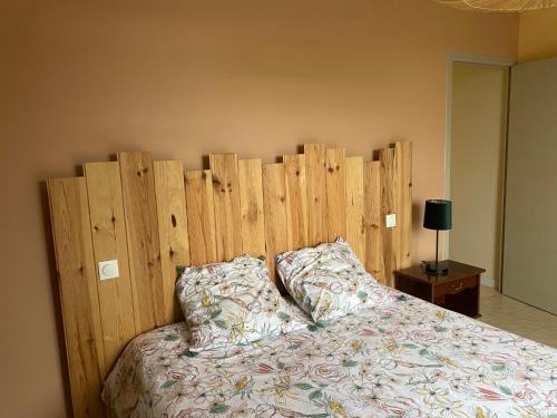 a bed with a wooden headboard in a bedroom at Le Hameau des Lavandes in Roynac