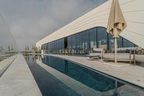 a building with a swimming pool next to a resort at IsLe Royal Suites By Mercury Tower in St. Julianʼs