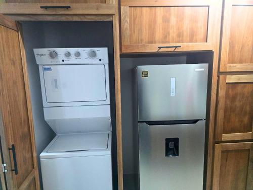 a kitchen with a refrigerator and a washer and dryer at Sunrise Apartments in San Felipe de Puerto Plata