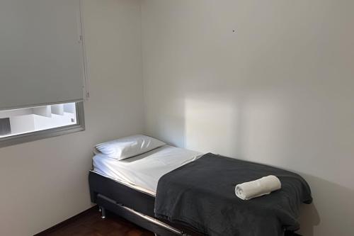 a small bed in a room with a window at Espaçoso apartamento perto Centro Sul e hospitais in Florianópolis