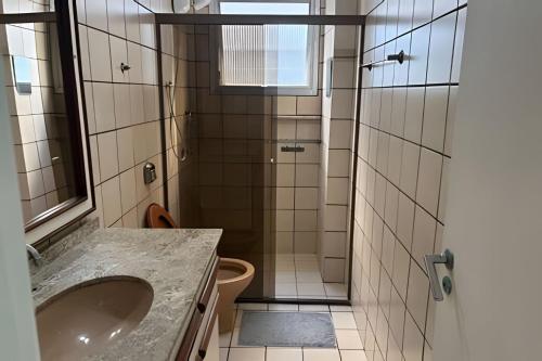 a bathroom with a shower with a sink and a toilet at Espaçoso apartamento perto Centro Sul e hospitais in Florianópolis