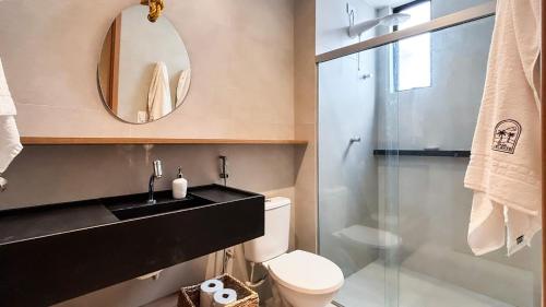 ein Badezimmer mit Waschbecken, Toilette und Spiegel in der Unterkunft Casa 3 Suítes Piscina e Hidro para até 9 pessoas in Tatuamunha