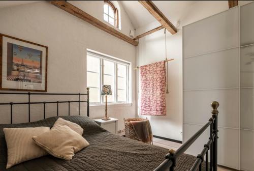 un dormitorio con una cama y una ventana en Visbylägenheter, en Visby