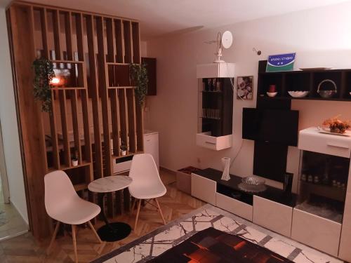a living room with white chairs and a television at Stan na dan-Vasilije in Zvornik
