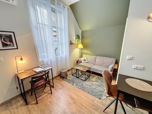a living room with a couch and a table at Le Trinity tout confort avec parking privé au centre ville in Vendôme