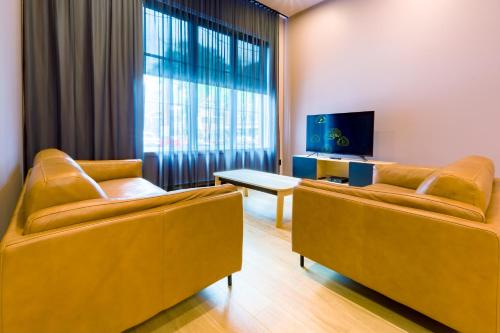 a living room with two couches and a tv at Les Lofts de la Fabrique - Par Les Lofts Vieux-Québec in Quebec City