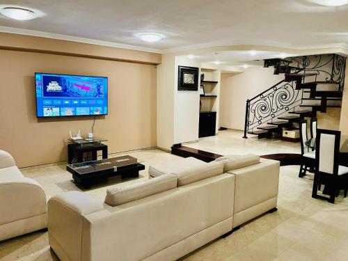 a living room with a couch and a flat screen tv at Terraza del Sol in Macuto
