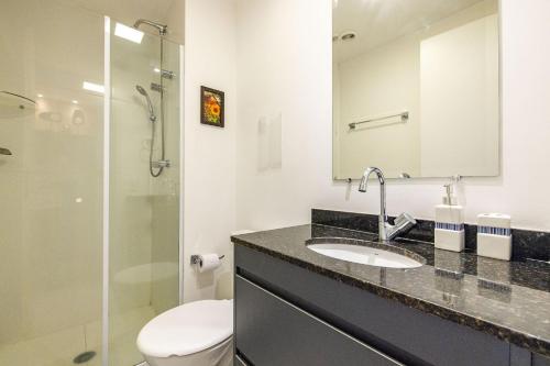 a bathroom with a sink and a toilet and a mirror at Studio mobiliado ao lado do aeroporto de Congonhas in Sao Paulo