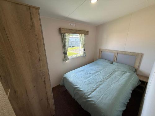 ein kleines Schlafzimmer mit einem Bett und einem Fenster in der Unterkunft Skegness Retreats The meadows 13 Golden Palm Resort Chapel st leonards in Chapel Saint Leonards