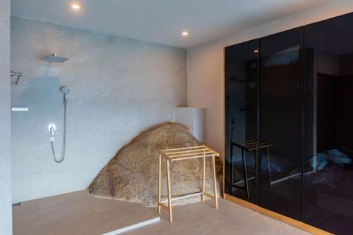 a bathroom with a shower and a large rock on the wall at Villa Cholchalee - By Sp Villa Management in Amphoe Koh Samui