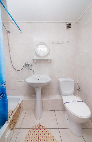 a white bathroom with a sink and a toilet at Hotel Druzhba in Kyiv