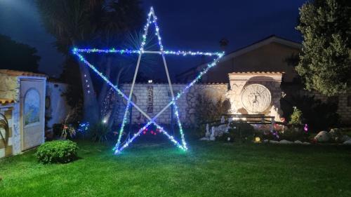 a lit up x star in a yard at night at La casa dell'artista in Ardea
