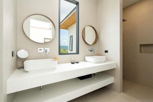 een badkamer met twee wastafels en twee spiegels bij Villa Nirvana by SP Villa Management in Koh Samui 