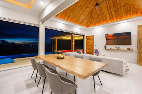 a dining room with a wooden table and chairs at Villa Nirvana by SP Villa Management in Koh Samui