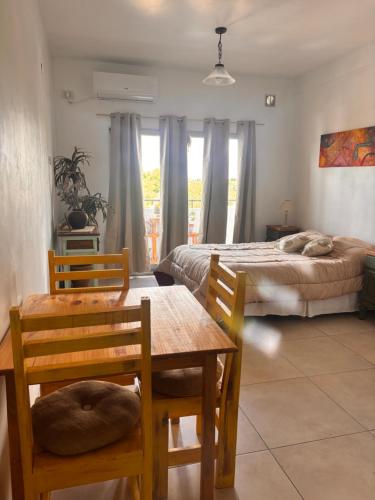 a bedroom with a bed and a table and chairs at Experiencia Brown a Mtros Sanatorio Juncal in Temperley