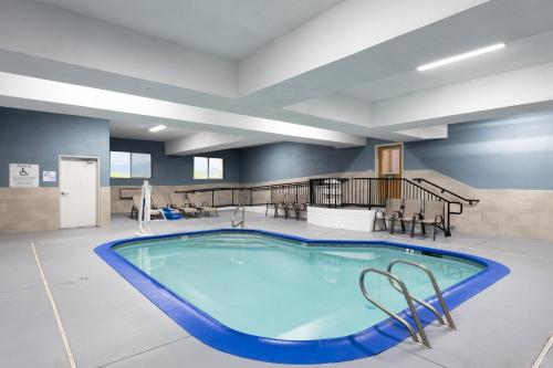 a large swimming pool in a large room with chairs and a staircase at Holiday Inn Express Redding North by IHG in Redding