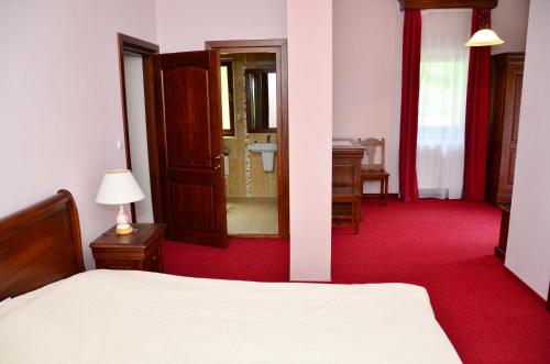 a bedroom with a bed and a red carpet at Pensiunea Valea Pinului in Rau Sadului