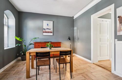 a dining room with a wooden table and chairs at Cozy central flat with terrace in Hinge