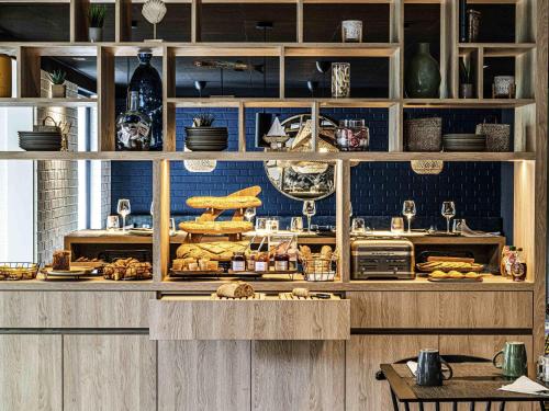 una cocina con un buffet con pan y otros alimentos en Novotel Lens Noyelles, en Noyelles-Godault