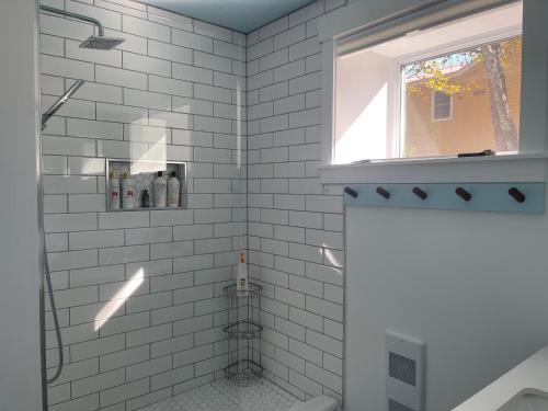 a white tiled shower with a window in a bathroom at Seas the Day Bed and Breakfast in Saint Andrews