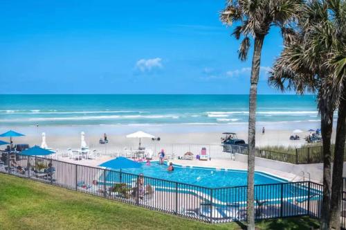 una vista de una piscina y la playa en Ocean Pool view I Beach front I Near Flagler 2BR, en New Smyrna Beach