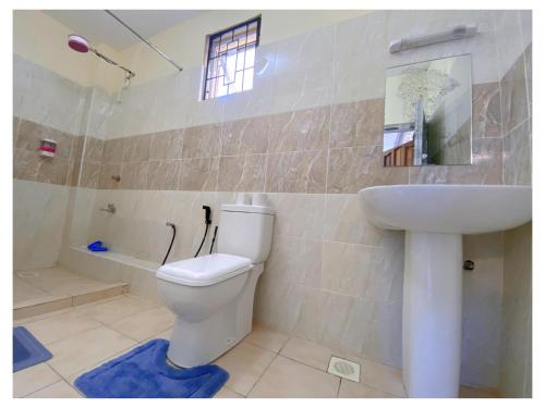 ein Badezimmer mit Toilette und Waschbecken in der Unterkunft Luxurious Pavilion Nest in Mombasa