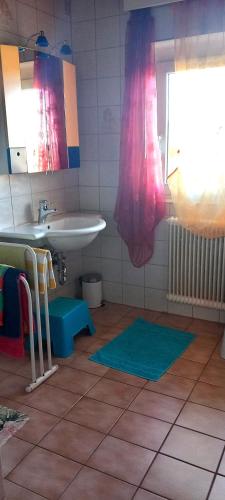 a bathroom with a sink and a mirror and a sink at Kunterbunt Seehaus in Faak am See