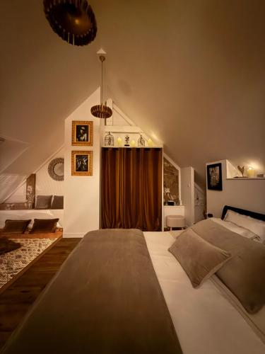 a bedroom with a large bed and a brown curtain at Ecrin de Charme in Granville