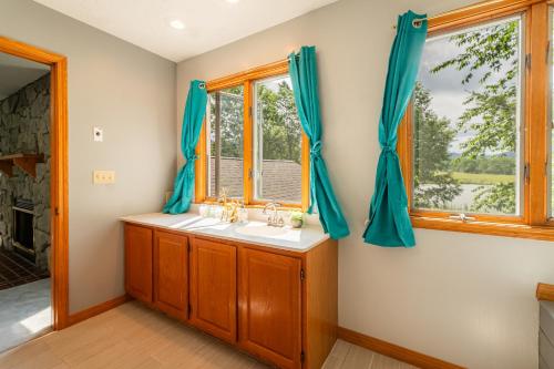 a bathroom with a sink and two windows at Panorama Point - Sauna, hot tub, theater room in Davis