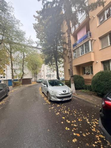 ein Auto, das auf einer Straße neben einem Gebäude geparkt ist in der Unterkunft Cozy Apartment 150 m from Târgu Mureș Hospital in Târgu Mureș