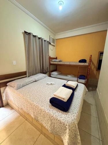 a bedroom with a bed with two towels on it at Pousada Recanto de Figueira in Arraial do Cabo