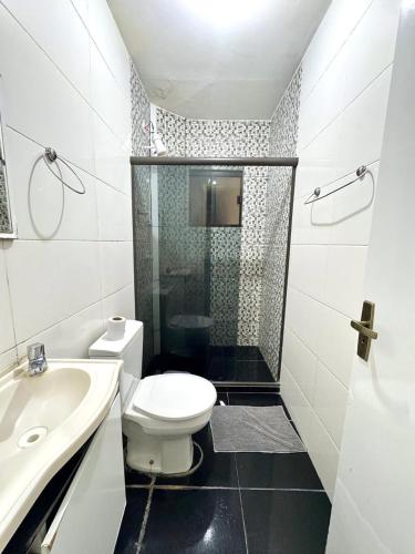 a bathroom with a toilet and a shower and a sink at Pousada Recanto de Figueira in Arraial do Cabo