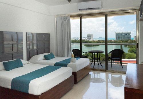a bedroom with two beds and a balcony with a view at Naia Mar in Cancún