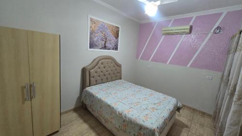 a small bedroom with a bed and a cabinet at Casa aconchegante A , 4 minutos do thermas in Andradina