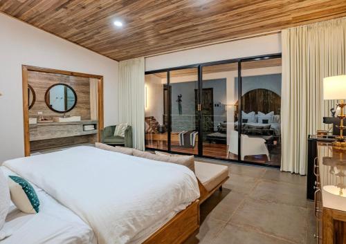 a bedroom with a large bed and a large window at Jungle Bungalow at Oropel Lodge in Puerto Viejo