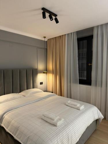 a bedroom with a white bed with two towels on it at Cuza Residence in Craiova