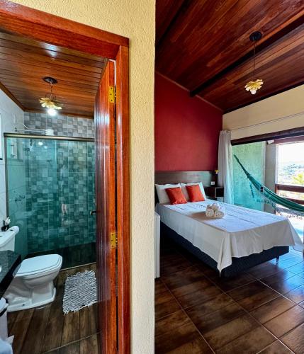 a bedroom with a bed and a shower and a toilet at Pousada Bela Vista do Ismail - Lapinha da Serra in Santana do Riacho