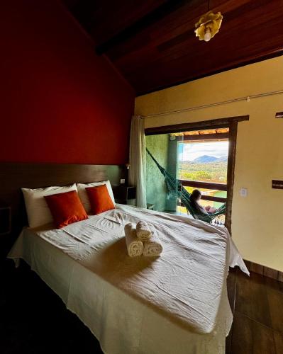 a bedroom with a large bed and a window at Pousada Bela Vista do Ismail - Lapinha da Serra in Santana do Riacho