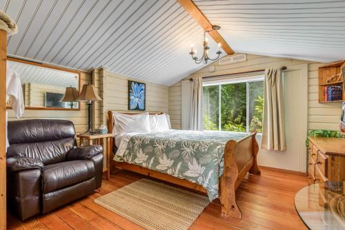 a bedroom with a bed and a leather chair at Saratoga beach cabin with hot tub in Oyster Bay