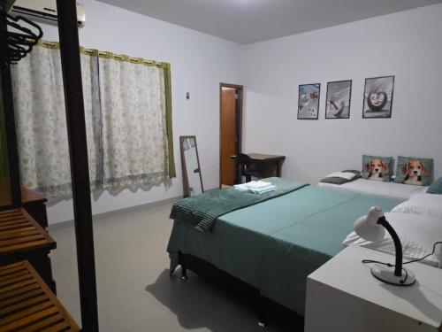 a bedroom with a bed and a desk with a lamp at Jardim Primavera in Palmas
