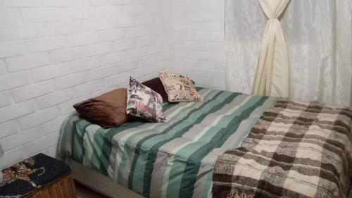 a bed with pillows on it in a room at Alojamiento Rústic in Santiago