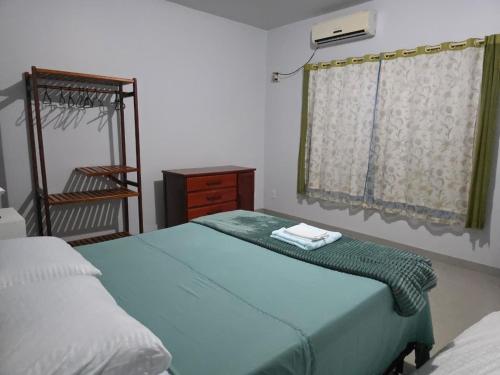 1 Schlafzimmer mit 2 Betten, einer Kommode und einem Fenster in der Unterkunft Jardim Primavera in Palmas